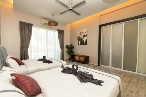 Habitación con 3 camas y ventilador de techo. en BalikPulau Cozy Home 4BR w BBQ, en Balik Pulau