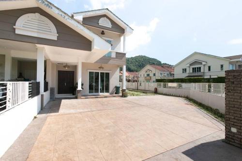 a driveway of a house with a white fence at BalikPulau Cozy Home 4BR w BBQ in Balik Pulau
