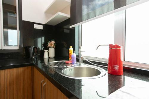 um balcão de cozinha com um lavatório e uma janela em BalikPulau Cozy Home 4BR w BBQ em Balik Pulau