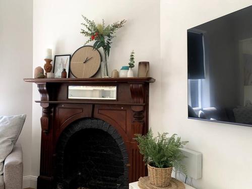 a living room with a fireplace with a mirror at Renovated Character Home in Invermay