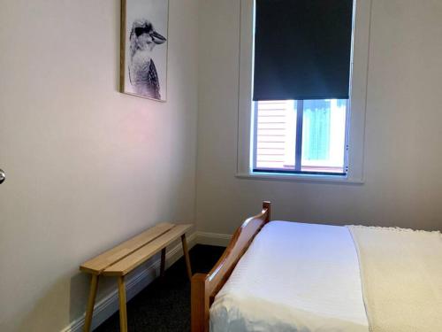 a small bedroom with a bed and a window at Renovated Character Home in Invermay