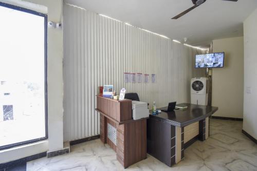 una oficina con escritorio y TV en la pared en Flagship 71214 Hotel Welcome Inn en Ludhiana