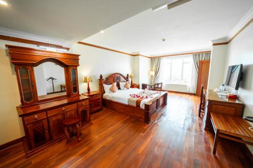 a bedroom with a bed and a desk and a mirror at Pursat Riverside Hotel & Spa in Pursat