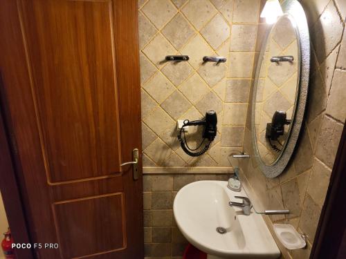 ein Bad mit einem Waschbecken und einem Spiegel in der Unterkunft APARTMENTS by climbing house in Kalymnos