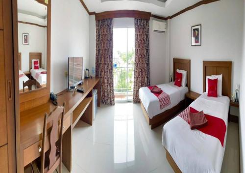 a bedroom with two beds and a desk with a mirror at Al Ameen Hotel in Krabi