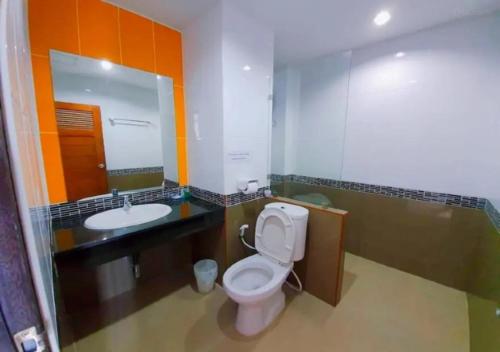 a bathroom with a toilet and a sink and a mirror at Al Ameen Hotel in Krabi