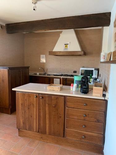 a kitchen with wooden cabinets and a white counter top at Borgo La Morra in Pavullo nel Frignano