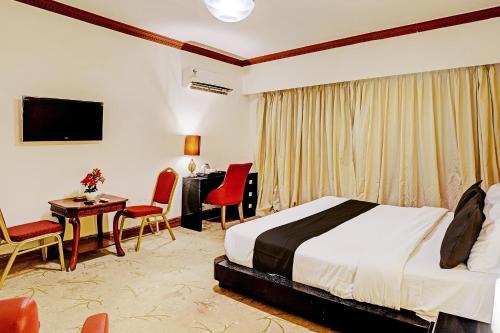 a hotel room with a bed and a desk and chairs at Townhouse Royal Palms Hotel - Lily in Mumbai