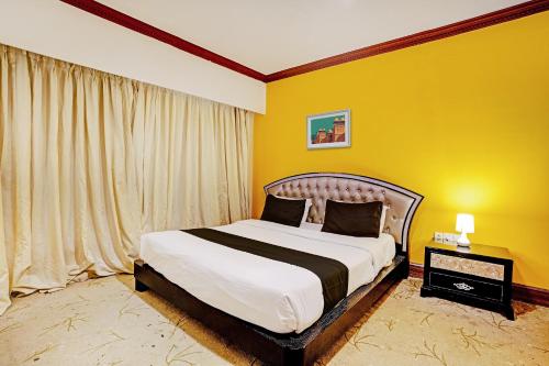 a bedroom with a bed and a yellow wall at Townhouse Royal Palms Hotel - Lily in Mumbai
