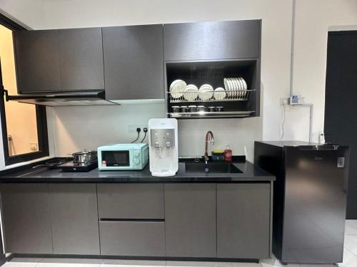 a kitchen with a counter with a microwave and a sink at 3 Room/3 Queen Bed, Urban Suite Arcade Room #2carpark in Jelutong