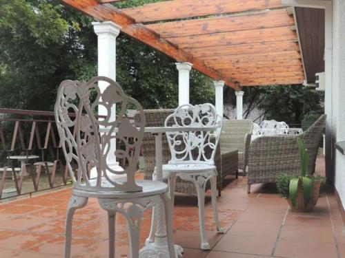 two white chairs and a table on a patio at Gentle Breeze Retreat in Parys