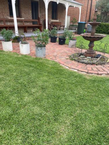 a brick yard with a fountain in the grass at A Homestead on Market in Mudgee
