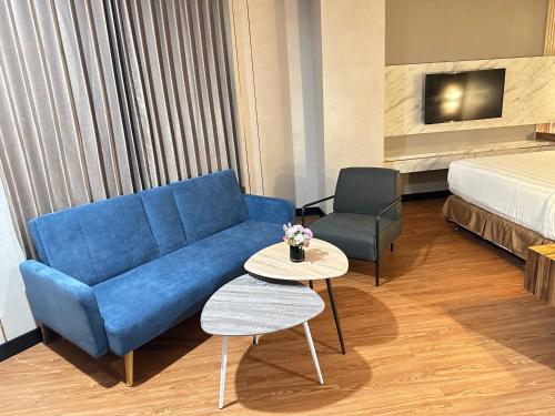 a hotel room with a couch and a bed at d'primahotel Jemursari Surabaya in Surabaya