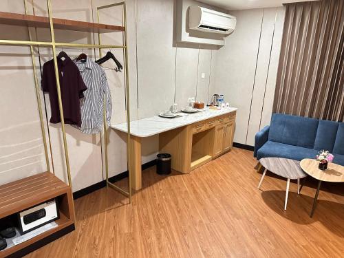 a hotel room with a desk and a blue chair at d'primahotel Jemursari Surabaya in Surabaya