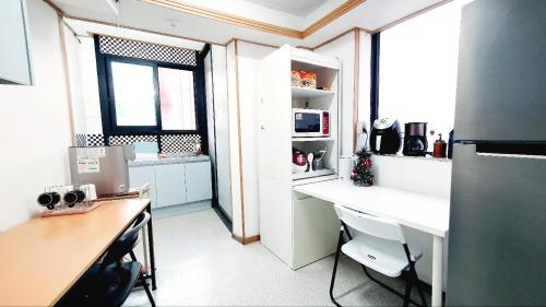 a kitchen with a desk and a refrigerator in it at Cony house in Seoul