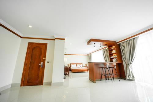 a living room with a wooden door and a table at Pursat Riverside Hotel & Spa in Pursat