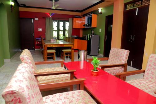 a living room with a red table and chairs at Hotel Park Treasure in Chitwan