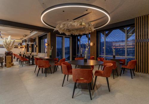 a dining room with tables and chairs and windows at Didukh Eco Hotel&Spa in Bukovel
