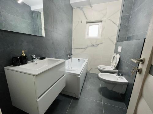 La salle de bains blanche est pourvue d'un lavabo et de toilettes. dans l'établissement AmurResidence ap5 2rooms freeParking private Sauna, à Iaşi