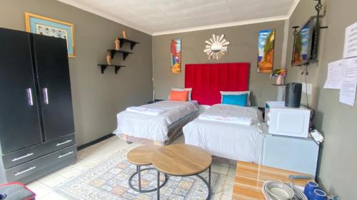 a living room with two beds and a table at Destiny Guesthouse in Germiston