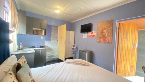 a room with a bed and a small kitchen at Destiny Guesthouse in Germiston