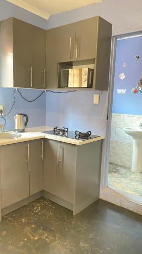 a kitchen with gray cabinets and a counter top at Destiny Guesthouse in Germiston