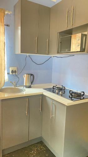 a kitchen with a sink and a stove top oven at Destiny Guesthouse in Germiston