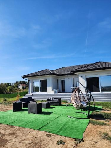 a house with a green lawn in front of it at NEW Luxury villa near Belgrade for 20 guests sleeps 8 in Vlaška