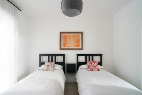 Duas camas num quarto com paredes brancas em Casa Bruna em Aosta