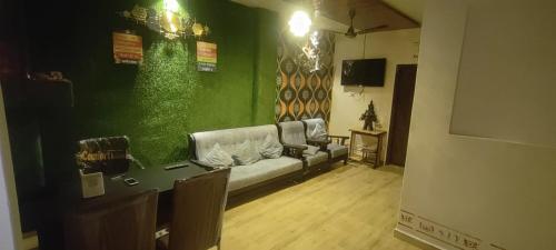 瓦拉納西的住宿－Raghuvanshi Paying Guest House，带沙发和绿色墙壁的客厅