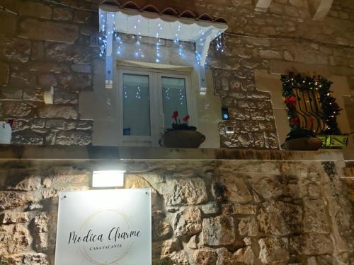 a window with christmas lights and a sign in a stone wall at Casa vacanze Modica Charme in Modica