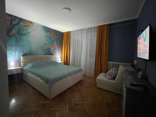 a bedroom with a bed and a couch in it at Apartman Avenia in Novi Sad