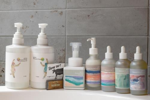 a group of four bottles sitting on a bathroom counter at e-ma ISHIGAKIJIMA TABISHIKA in Ishigaki Island