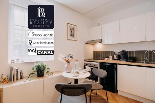 une cuisine avec une petite table blanche et des chaises dans l'établissement Bel écrin sur l'île de Nantes - GARE TGV, CHU, CONGRES, à Nantes