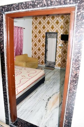 a mirror in a room with a bed and a couch at Ramaya’s Home Stay in Varanasi