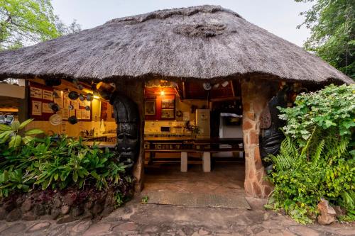 a small hut with a table and a straw roof at Victoria Falls Backpackers Lodge- Camp Sites in Victoria Falls