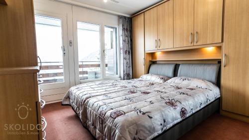 1 dormitorio con cama y ventana grande en Apartment Riederhof, Riederalp, en Riederalp