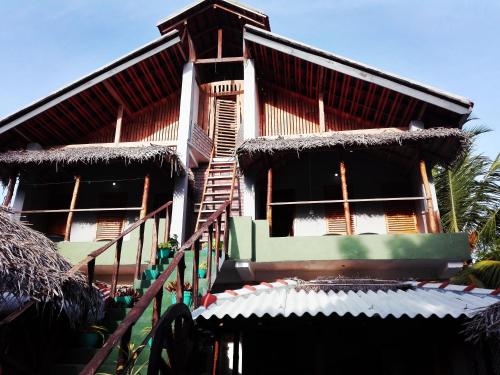 un edificio con una escalera delante de él en Neem Forest Guest House & Yoga Meditation Centre, en Batticaloa