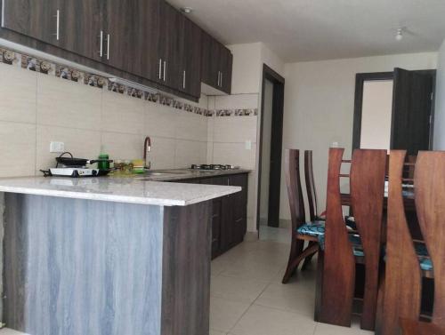una cocina con encimera y algunos armarios de madera en departamento individual equipado, en Ibarra