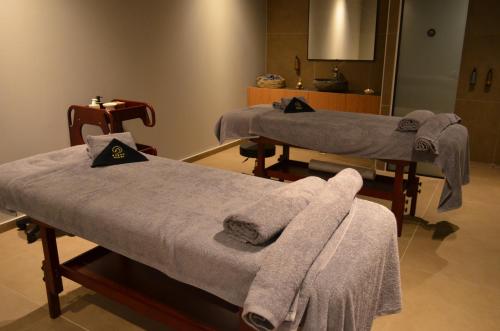two beds in a room with towels on them at Cook's Club Ialysos Rhodes in Ialyssos