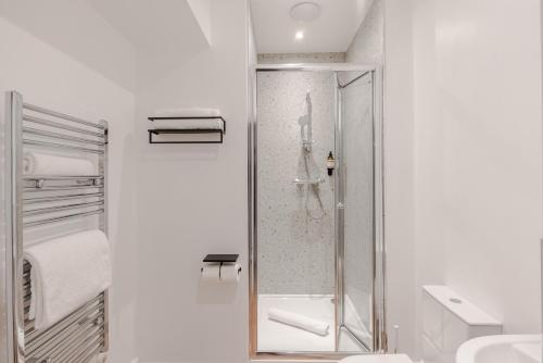 a white bathroom with a shower and a toilet at Redland Place - Your Apartment in Bristol