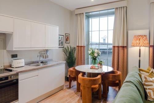 a kitchen and living room with a table and a couch at Redland Place - Your Apartment in Bristol