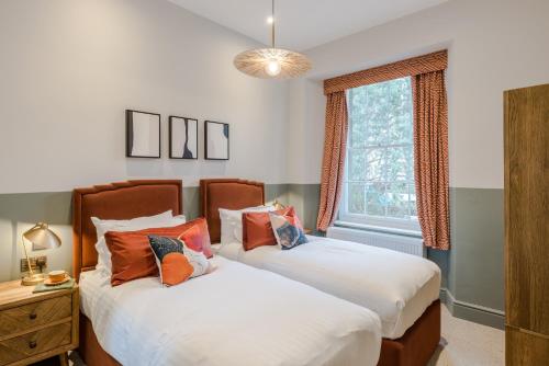 a bedroom with two beds and a window at Redland Place - Your Apartment in Bristol