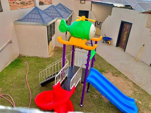 un parque infantil con un tobogán en el patio trasero en مربط الجازي en Ad Dihāsīyah