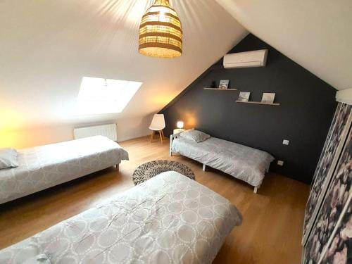a attic bedroom with two beds and a large window at Châteauroux L’O'thentik' Duplex 7 pers in Châteauroux