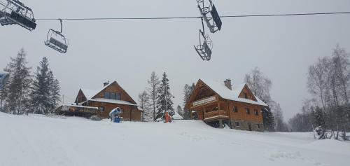 a ski lodge in the snow next to a ski lift at Apartamenty na Soszowie, Wisła - widokowe miejsce z Balią & Prywatną Sauną, obok stoku narciarskiego i Bike Parku, dla max 16 osób in Wisła