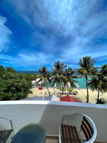 a view of a beach and palm trees from a balcony at Leisure Boutique Maafushi 维尼家 in Maafushi