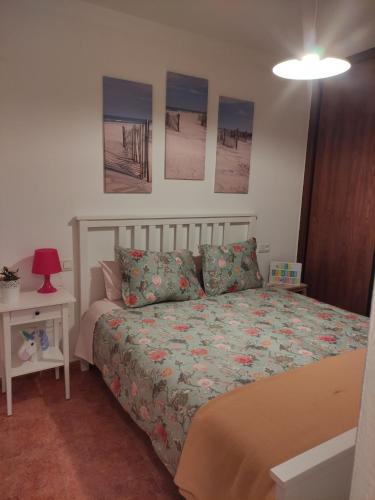 1 dormitorio con 1 cama y algunas fotos en la pared en Timón, cerca de la Playa, en Candás