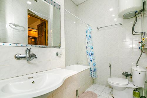 a bathroom with a sink and a toilet and a mirror at Monolit Apartment in Baku