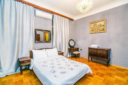 a bedroom with a bed and a dresser and a mirror at Monolit Apartment in Baku